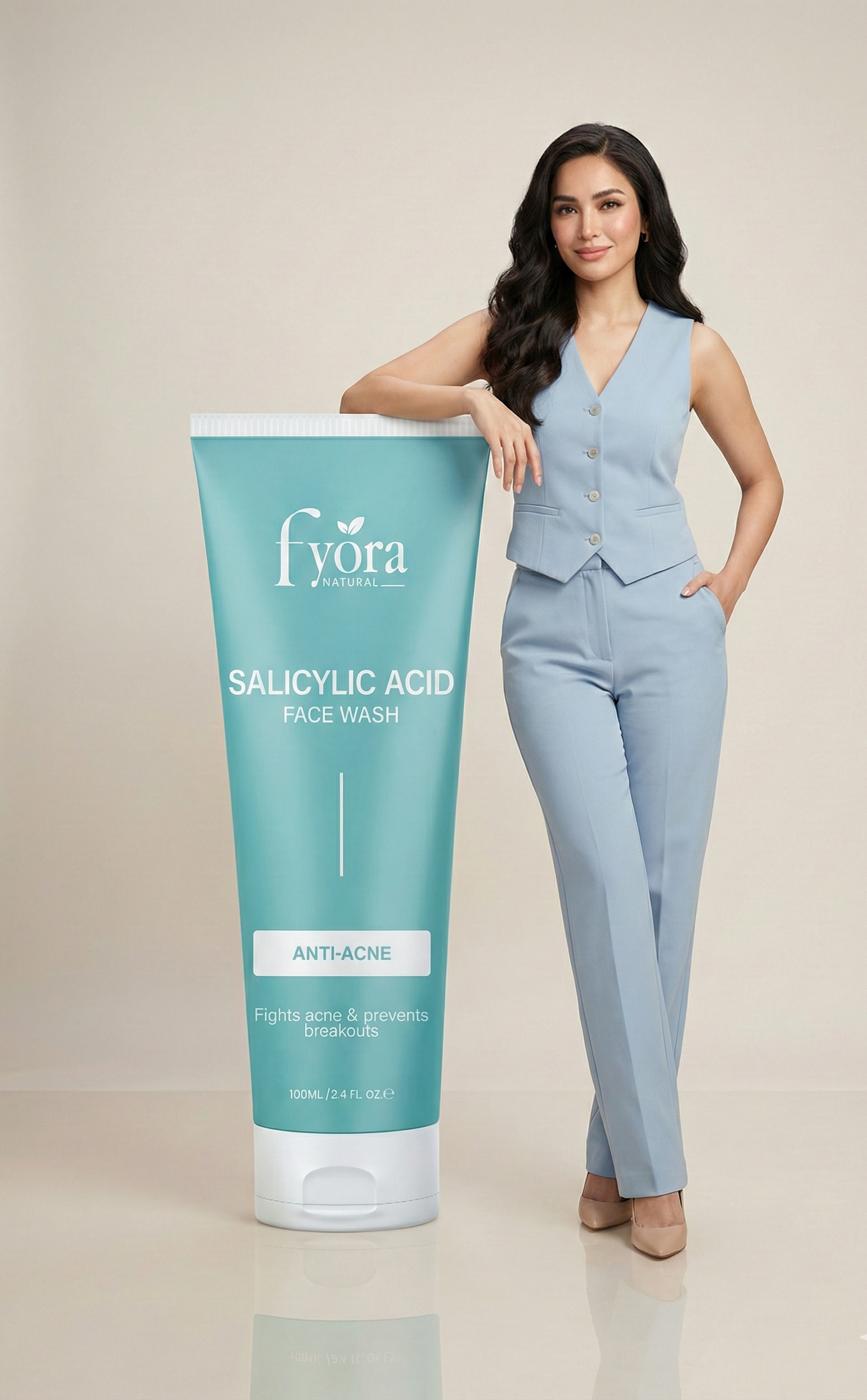 Woman in a light blue outfit standing next to a large tube of Fyora Salicylic Acid Face Wash on a beige background