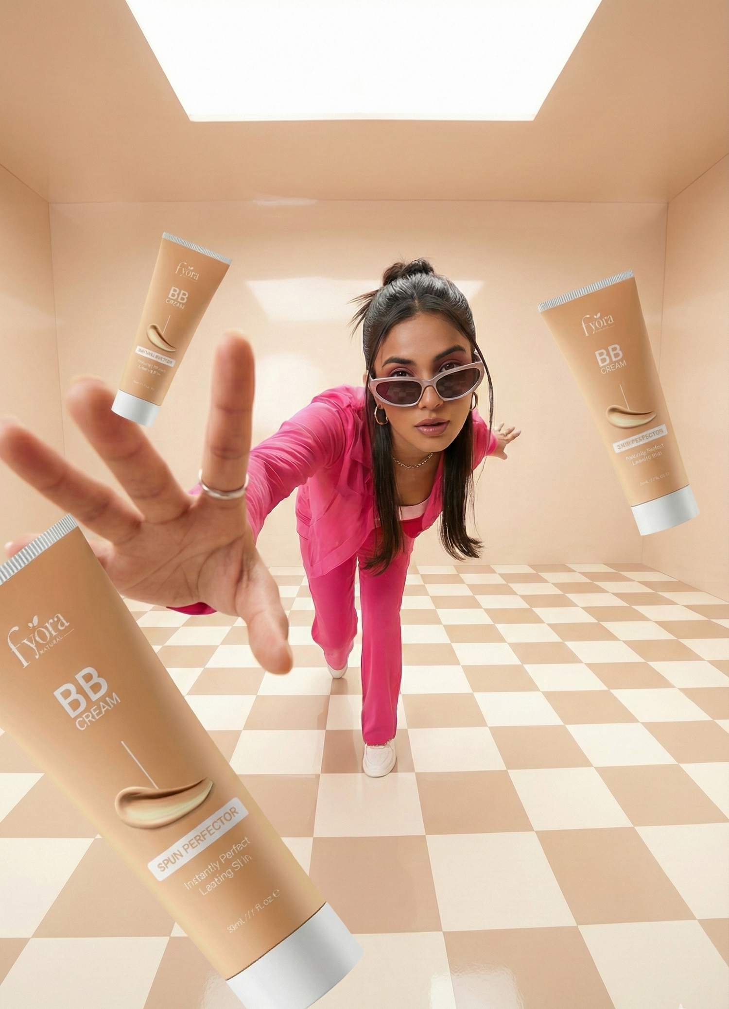 Woman in pink outfit with sunglasses surrounded by BB cream tubes in a checkered room.